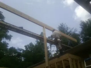 Carpenter setting a ridge beam over a new addition frame — Ice Dam Removal by Roofing Brothers in Attleboro
