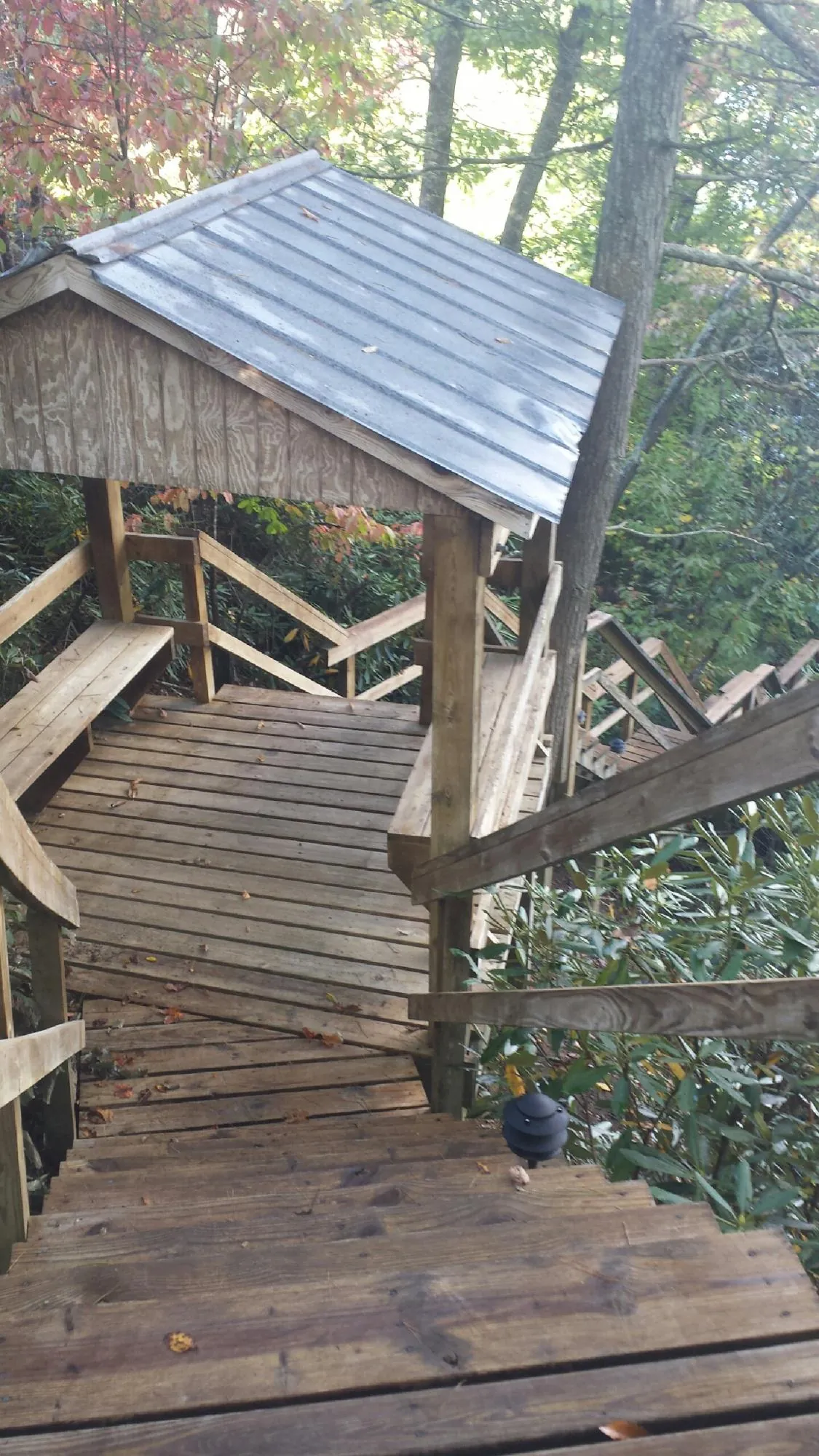 Metal roofed shelter over wooden steps on a wooded walkway — Skylight Repair & Installation work by our crew in Attleboro