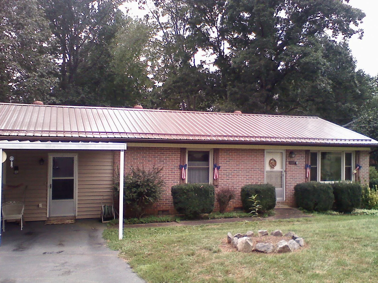 Bronze metal roof and carport on a brick ranch home — Roof Repair work by our crew in Attleboro